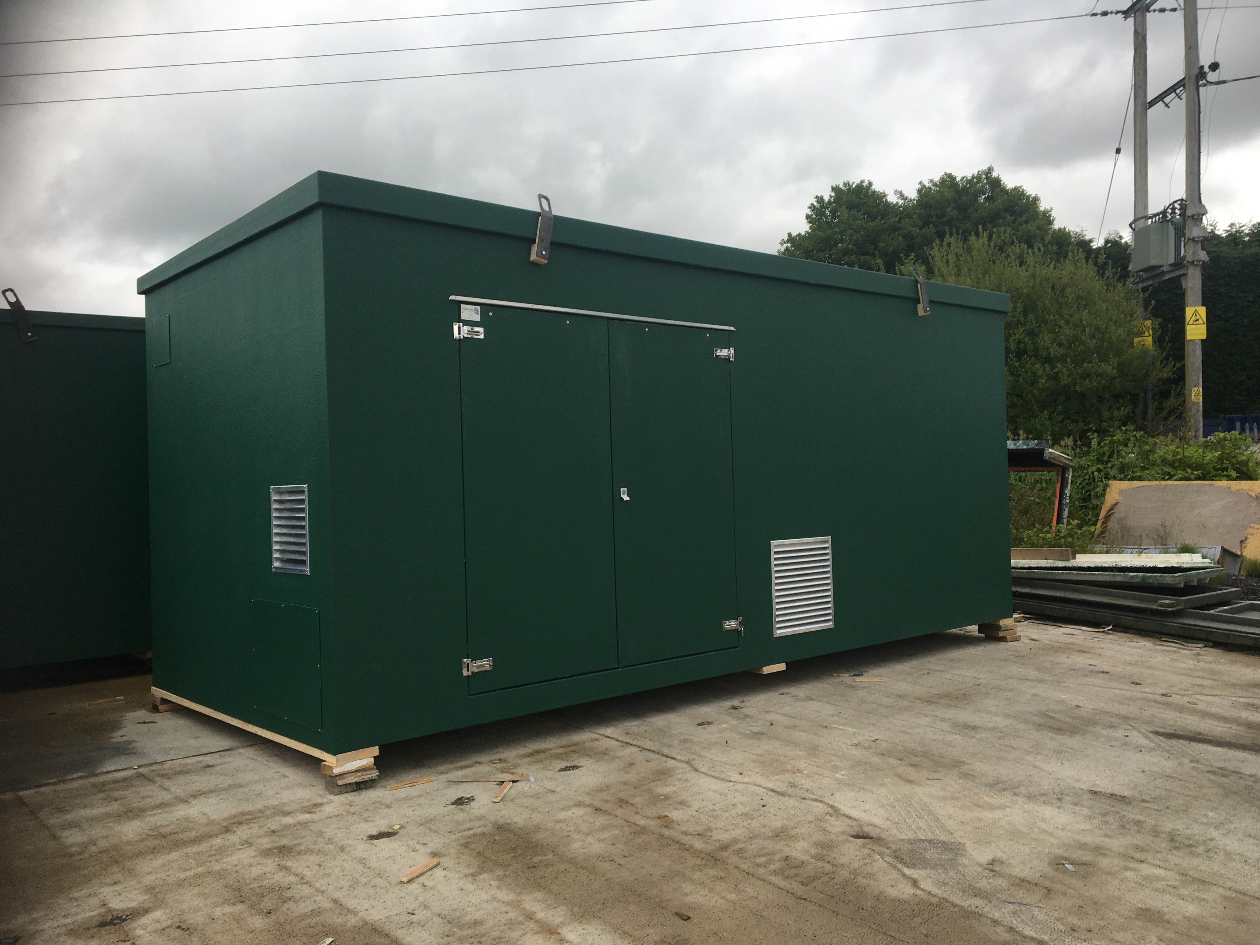 Green GRP enclosure with service access doors and ventilation