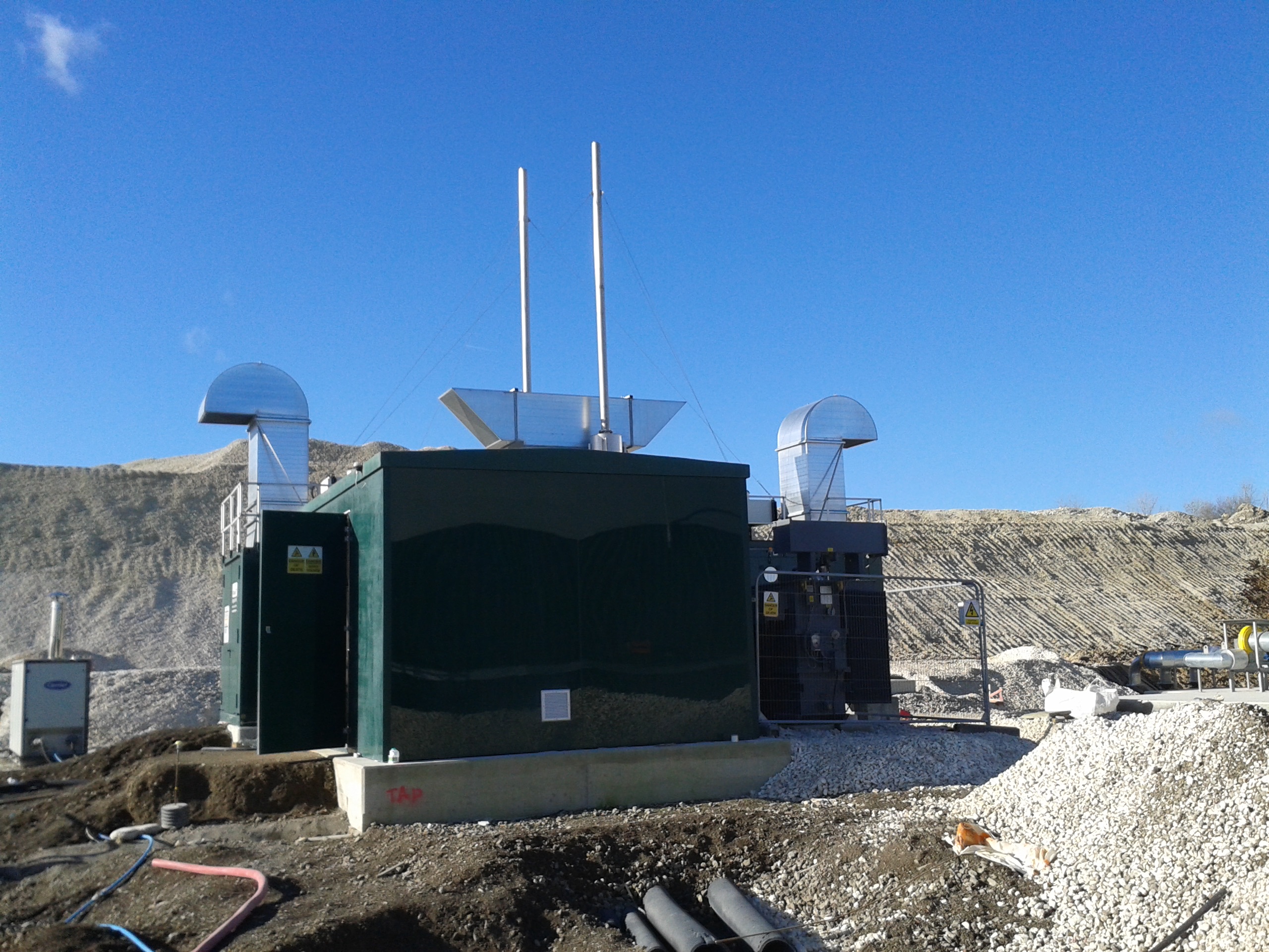Large green GRP enclosure installed with industrial equipment