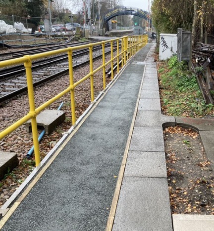 Yellow GRP handrail beside a rail access route