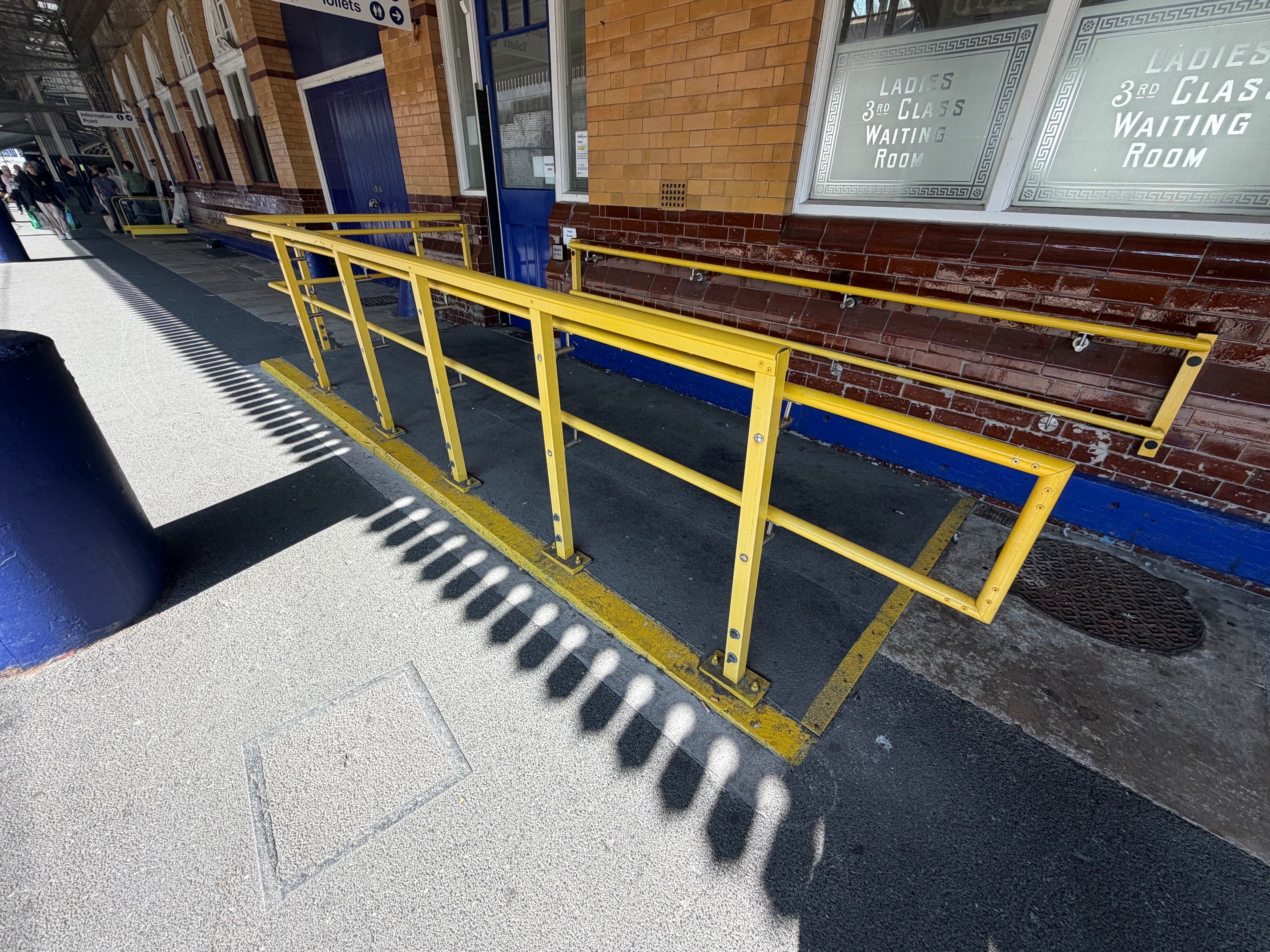 Yellow GRP handrails at a railway station