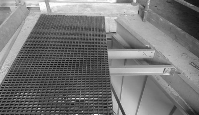 GRP grating installed across a service riser with structural supports